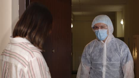 medical worker with text on paper visiting woman at home offering vaccination against coronavirus