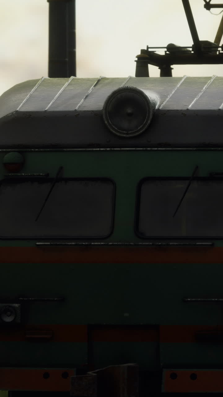 Train engine moving through fog in a rural area during early morning