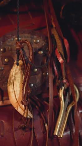 feather curved from bone leather laces and vargan hand on shaman costume extreme close view. tribal accessories of altai folks. culture conservation