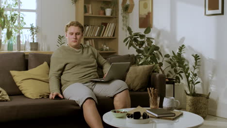 Young-blond-boy-sitting-on-the-sofa