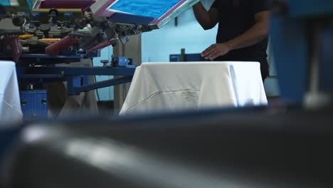 medium abstract view of fabric moving through screenprinting machine rotating through layers, showcasing design application and vibrant details