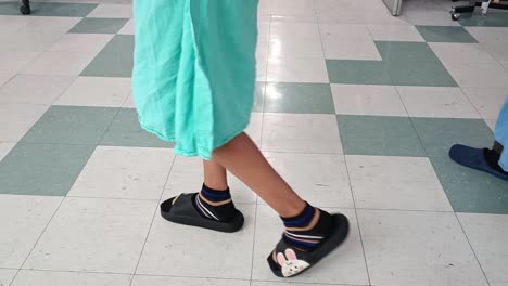 children in hospital gowns walking down a hospital hallway