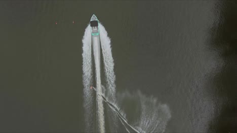 aerial headshot of wakeboarder towing boat on the river