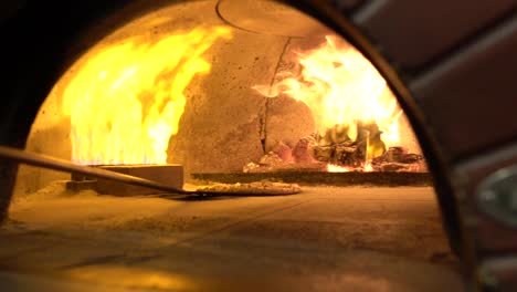 moving around pizza base in brick oven slow motion
