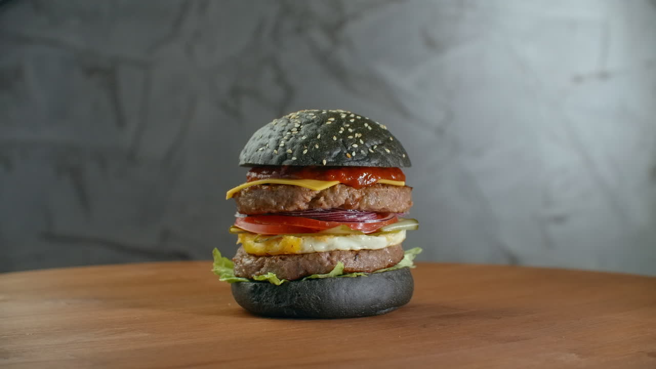 hamburguesa negra con verduras griegas hamburguesa negra en una mesa de madera