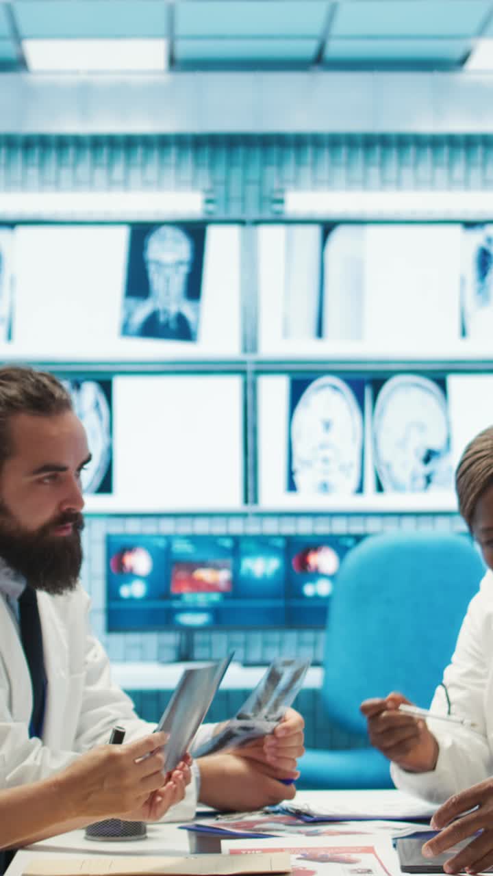 Vertical Video Radiologists and doctors analyze x rays and discuss patient care in office