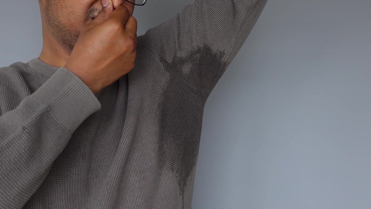 Man Checking Underarm Sweat Stains on Shirt