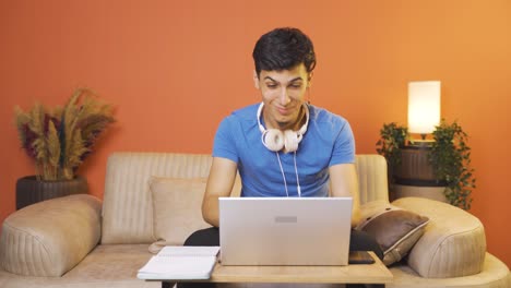 hombre mirando la computadora portátil haciendo un gesto positivo.