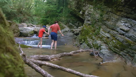 mother and son hiking in a creek