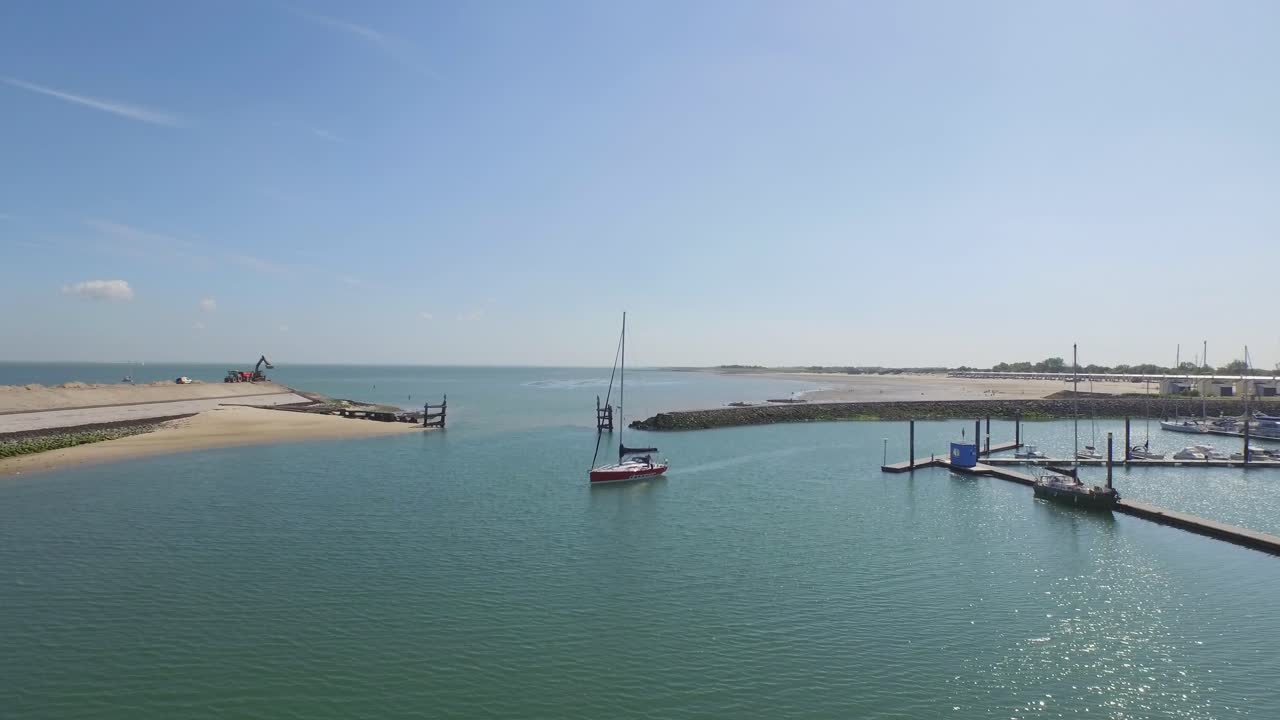Sailboat entering harbor on a sunny day