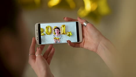 manos sosteniendo un teléfono que muestra un video de fin de año