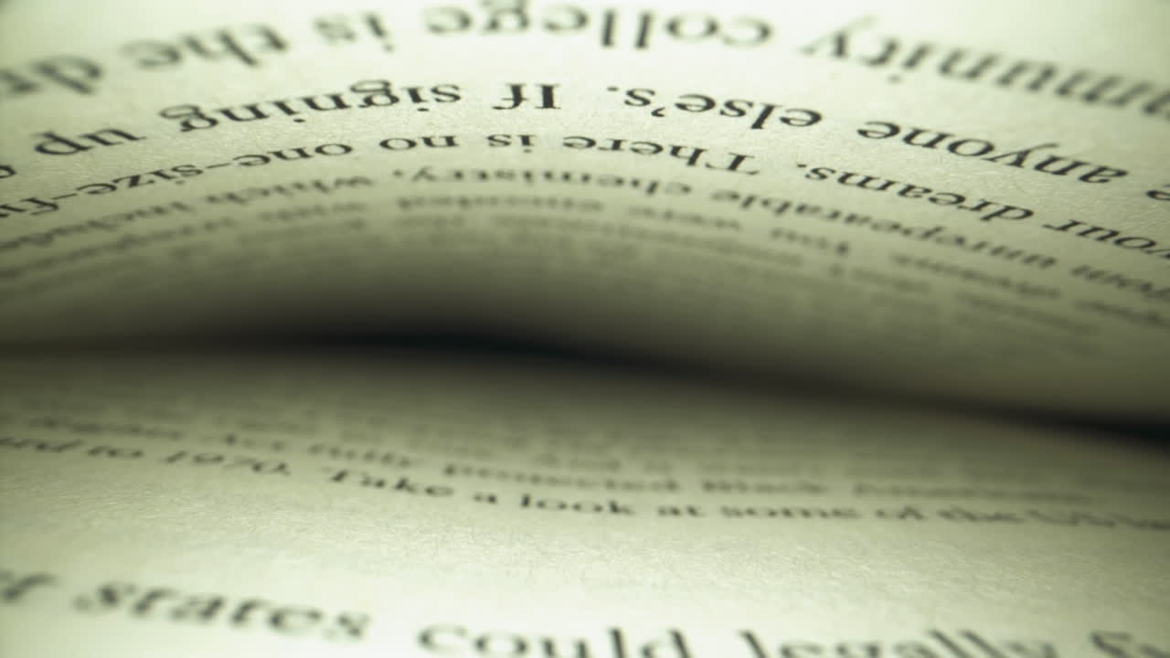 Unique perspective slider shot inside of a book as camera slowly backs out from the page