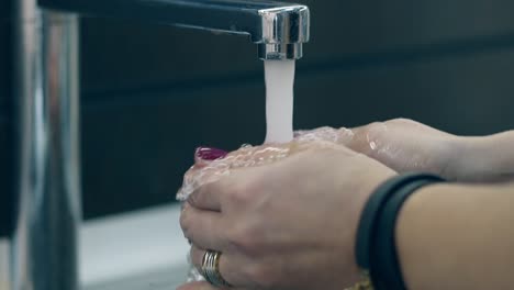 mujer lava bien la manzana grande en la cocina del restaurante