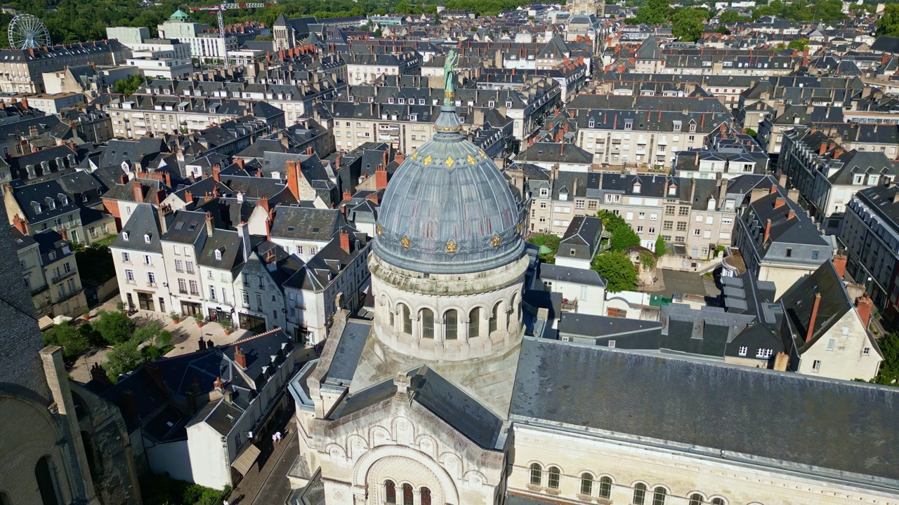 Receding drone shot revealing dome and full Basilica Saint Martin surrounded by city houses