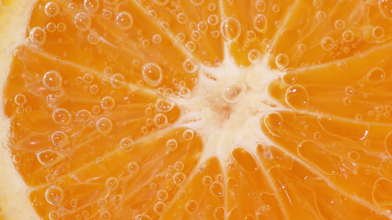 공기 거품이 있는 물 에 있는 둥근 만다린 조각.