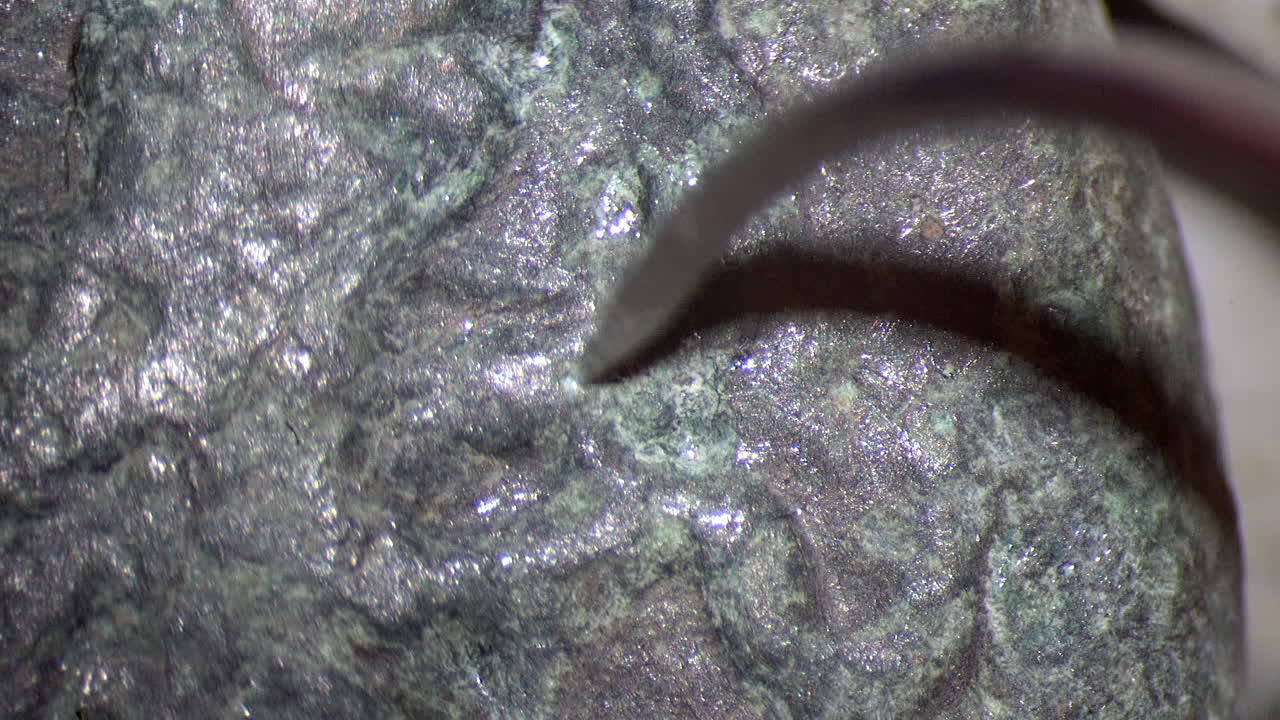 Curved conservation needle probes at corrosion on ancient Greek tetras coin