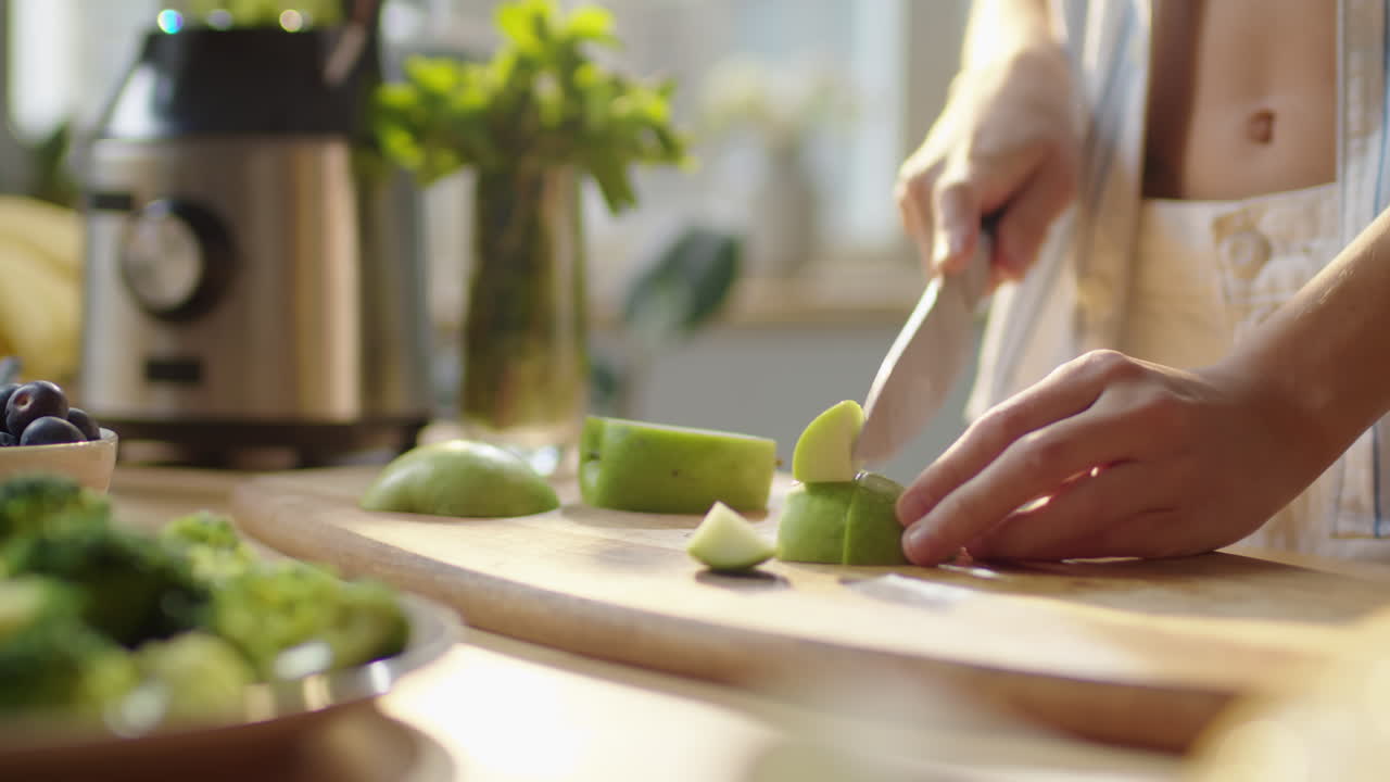 Hands of Woman Cutting Green Apple
