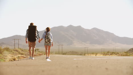 Couple-On-Vacation-Hitchhiking-Along-Road-Shot-On-R3D