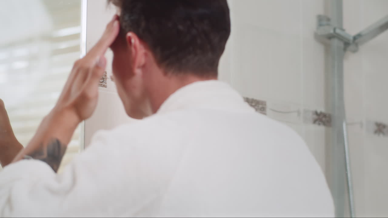 Young Man Smearing Cream over Face