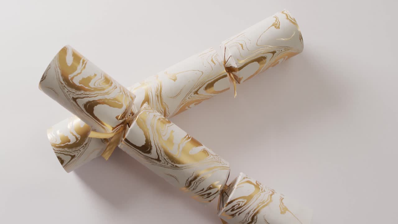 두 개의  ⁇ 색과 금색 크리스마스 크래커와  ⁇ 색 배경에 있는 복사 공간의 비디오