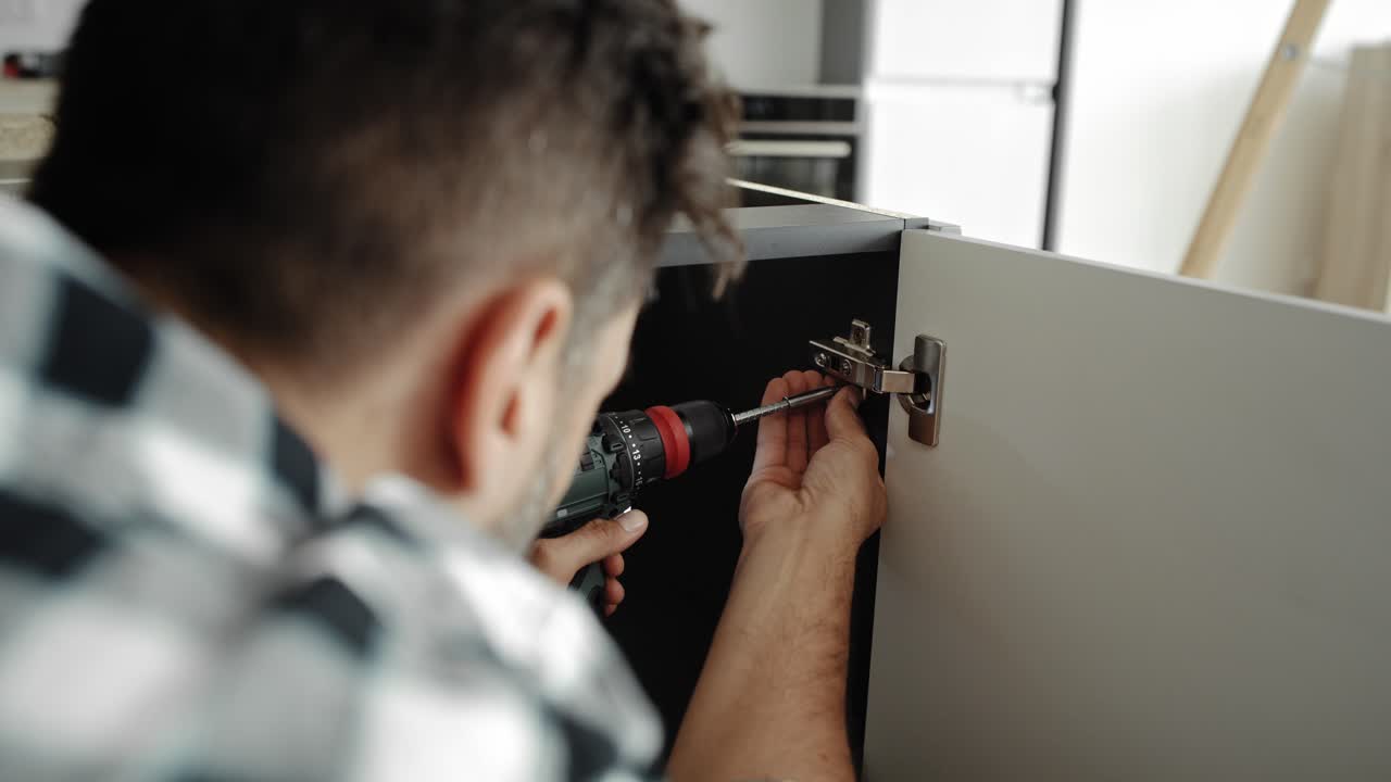 Rear view video of screwing hinges with a cordless screwdriver