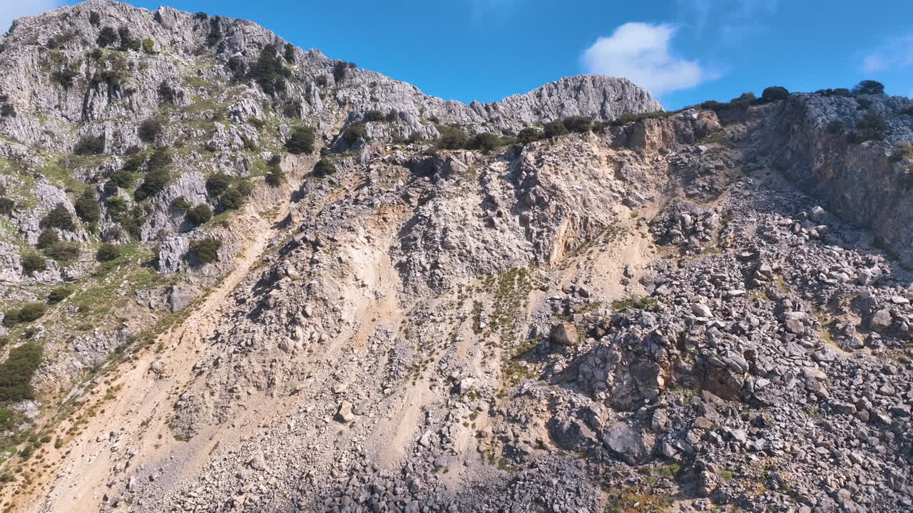 Aerial smoothly traverses steep mountain bluffs and tenacious plants Axarquia