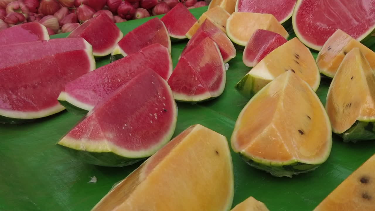 fruta de sandía en rodajas rosa y amarilla en la mesa para vender con moscas domésticas
