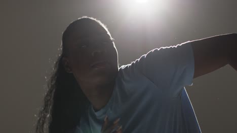 backlit head and shoulders studio portrait shot of young woman dancing in spotlight 1