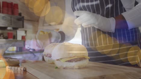 animation of dots over hands of afrcian american man preparing burgers