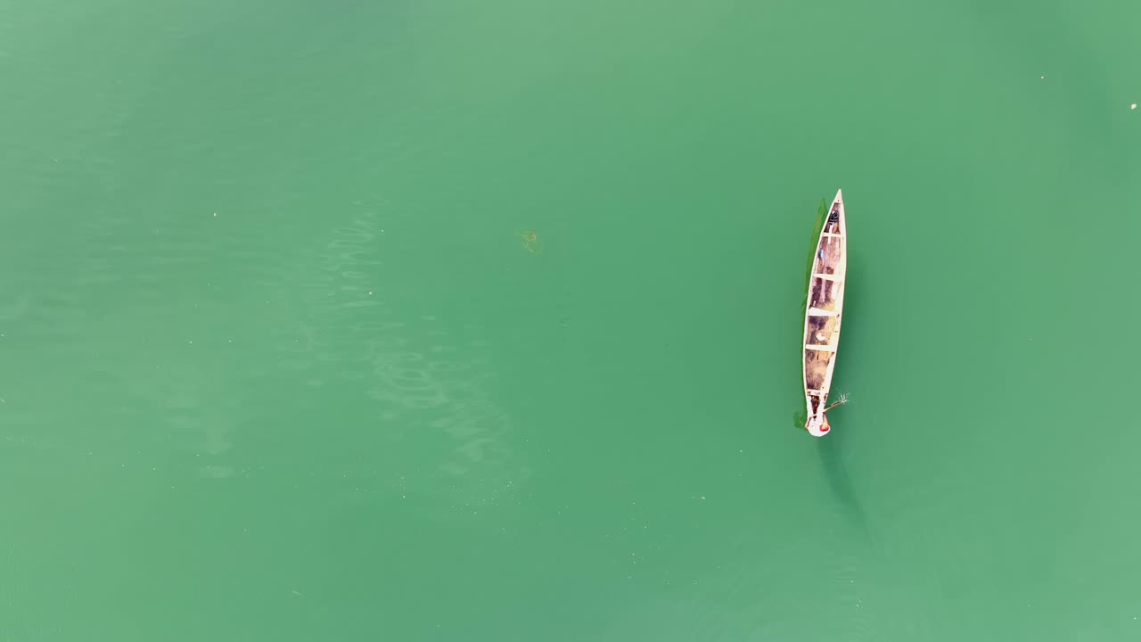 antena - pescador solitario remando su canoa a través de un hermoso lago