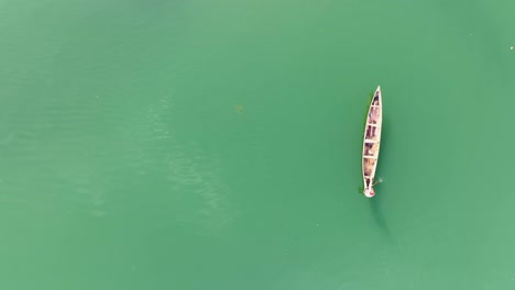 aerial - lone fisherman paddling his canoe across a beautiful lake