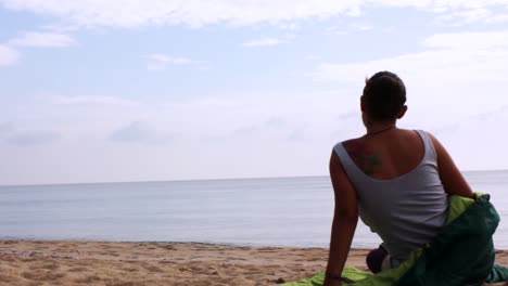 girl wakes up at the beach in her sleeping bag