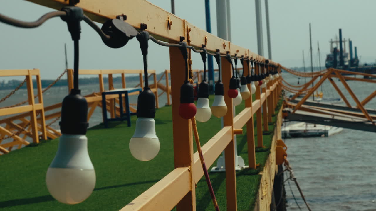 The path to the pier has light bulbs mounted on the bridge