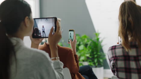 Joven-Mujer-De-Negocios-Hispana-Compartiendo-Ideas-Corporativas-Con-Colegas-Del-Grupo-De-Gestión-Usando-Videos-De-Filmación-De-Teléfonos-Inteligentes-Disfrutando-De-Presentaciones-Compartidas-En-Las-Redes-Sociales-En-Una-Reunión-De-Seminarios-En-La-Sala-De-Juntas