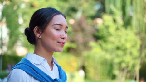 cheerful woman takes a deep breath outdoors