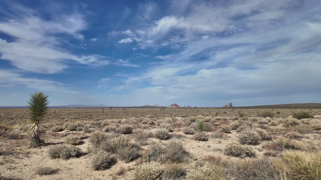 This stunning 24-second 4K Ultra HD time-lapse video captures the serene beauty of the Mojave Desert. Wide shot of the expansive desert landscape, sparse vegetation and distant hills