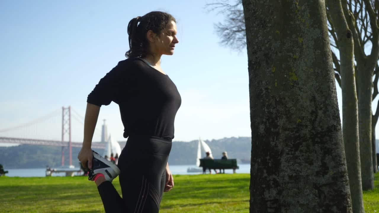 mujer joven en ropa deportiva estirándose en el parque