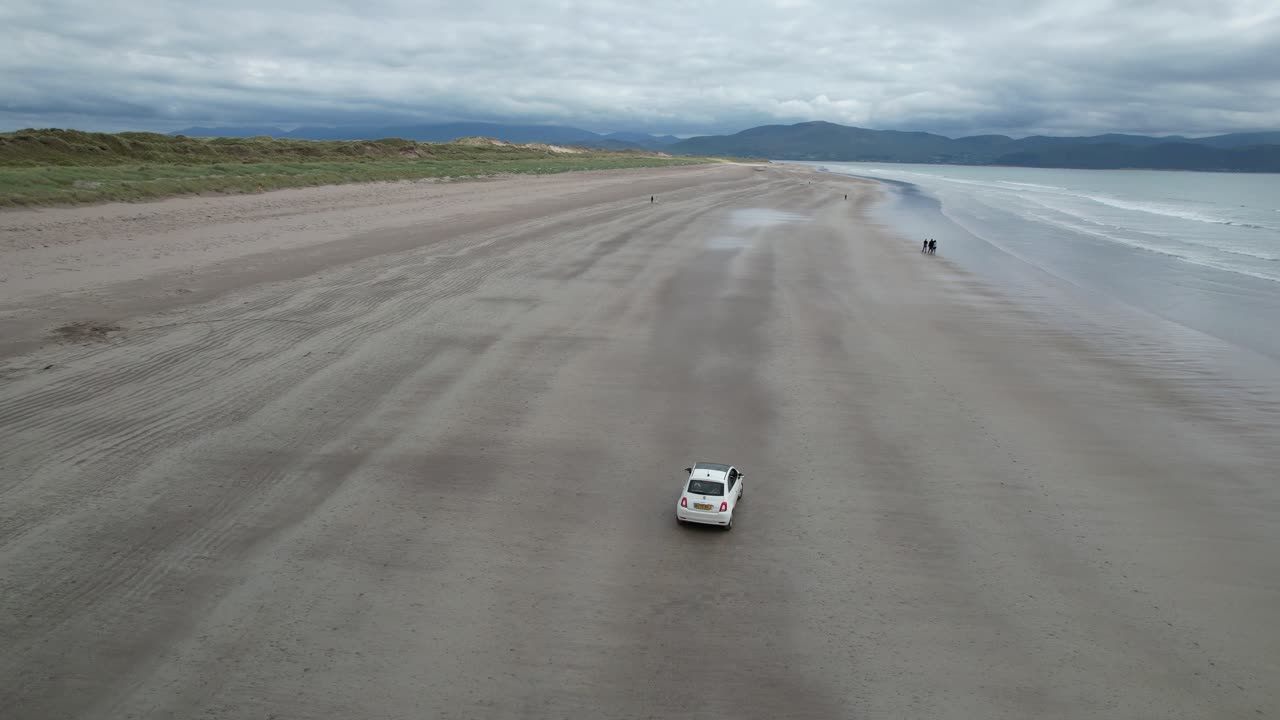 Drone tracking car driving on Inch beach Dingle peninsula Ireland