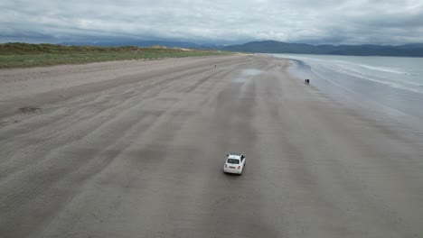 drone tracking car driving on inch beach dingle peninsula ireland