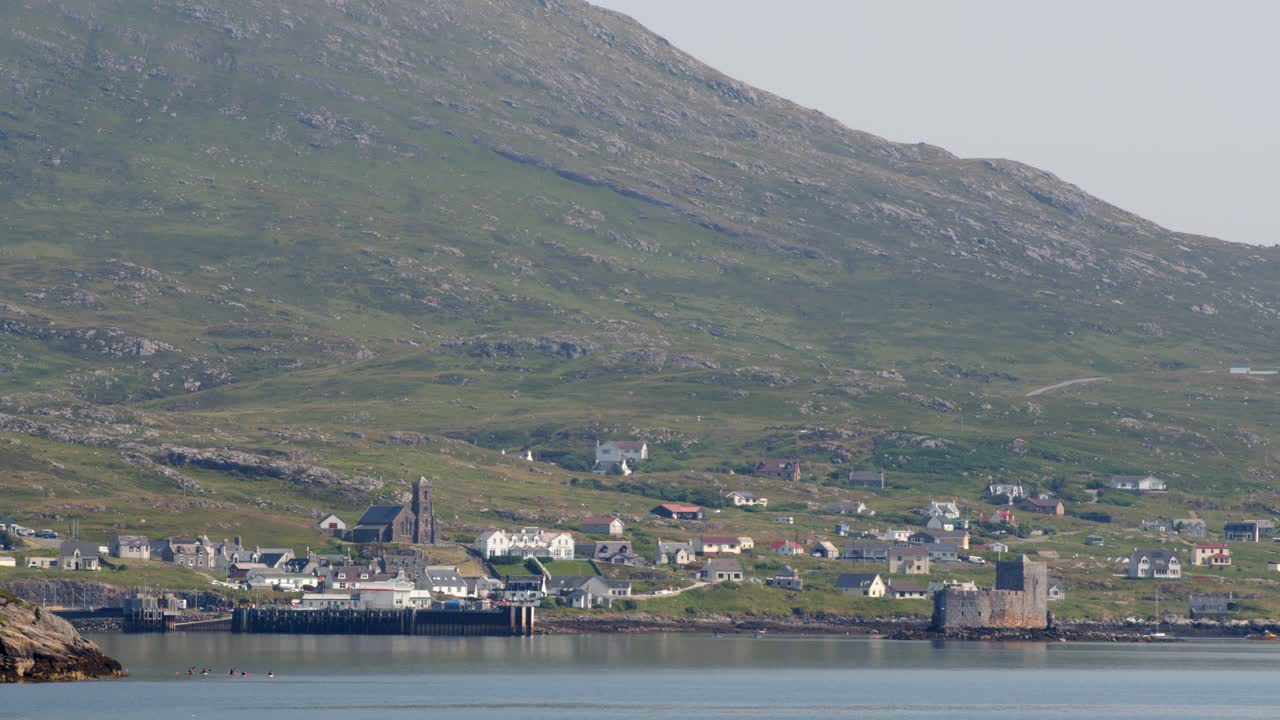 Shot of a group of kayakers paddling in the sea near the village of Castlebay
