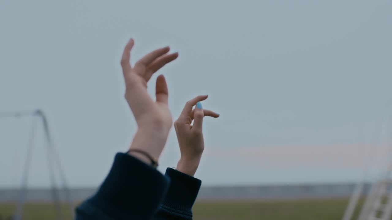 자유 개념을 탐험하는 놀이터 공원에서 회전하는 회전목마를 즐기면서 회전 목마에서 팔을 들고 있는 젊은 여성