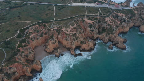 Establishing-aerial-drone-view-of-scenic-outdoor-coastline-in-Lagos,-Portugal,-circling-pan-above-Atlantic-ocean,-cloudy-day