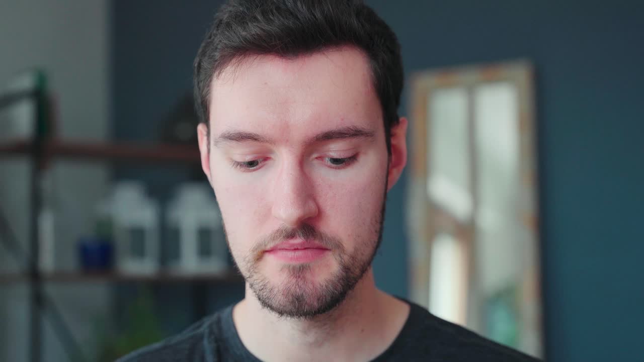 Young caucasian man bites into burger, burger eating pleasure, close up portrait fast food eating, unhealthy eating concept obesity, eating at home alone lonely