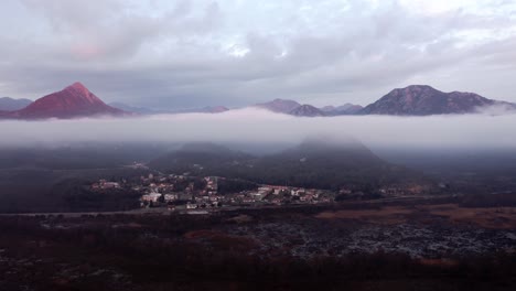 aéreo - nubes bajas sobre el pueblo de montaña en el lago skadar, montenegro, adelante