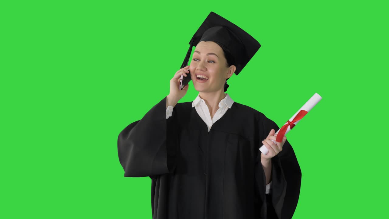 Studentessa emozionata in toga di laurea che parla al telefono tenendo in mano il diploma su schermo verde, Chroma Key