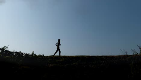 Slow-motion-of-silhouetted-man-running-on-bright-sunny-day