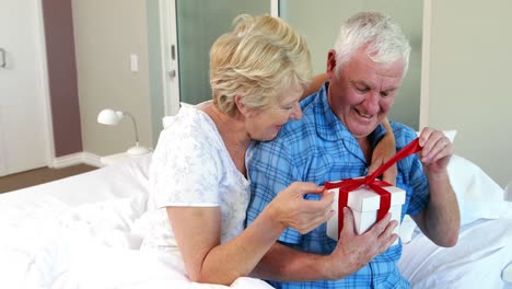 Senior-woman-offering-present-to-husband