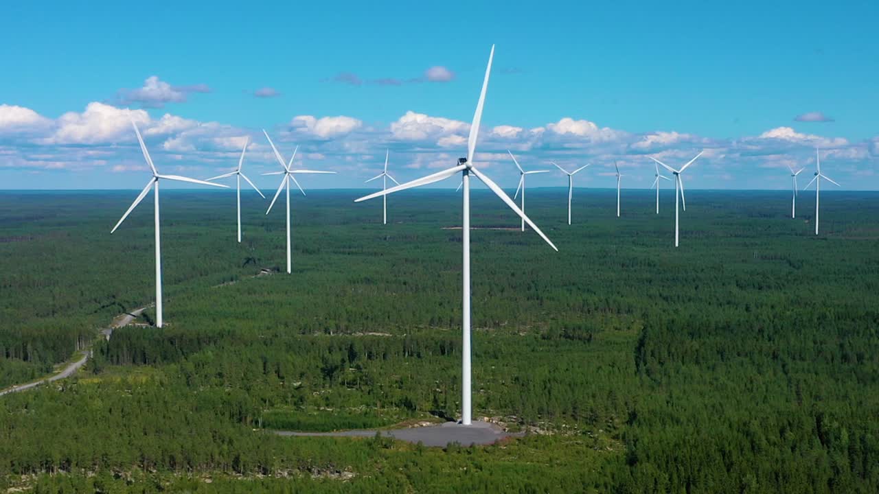 Aerial view of a lot of wind power turbines at a wind energy farm, on a sunny, summer day, in Satakunta, Finland - Dolly, drone shot