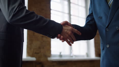 Business men exchange envelope concluding successful deal on meeting close up.