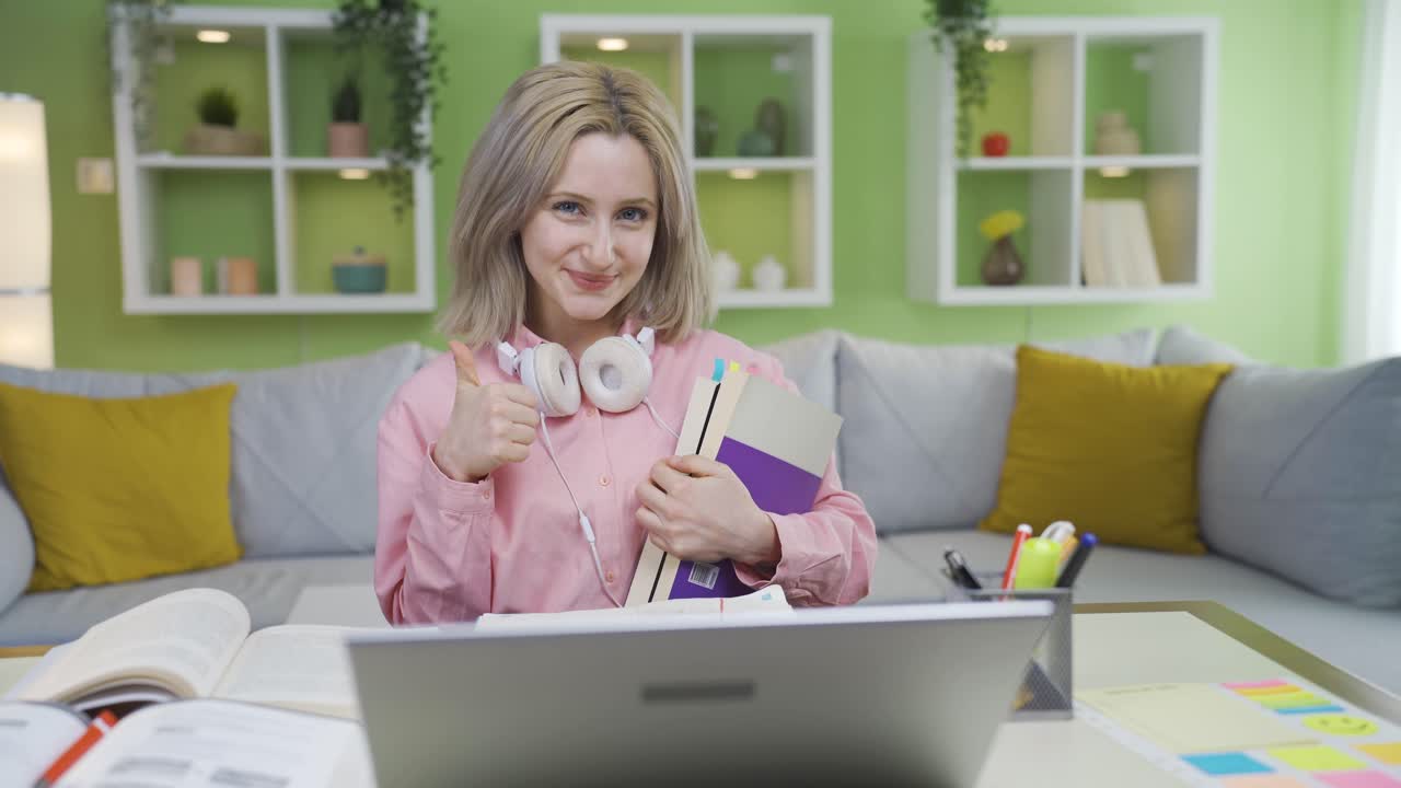University student girl holding books makes gesture of satisfaction at camera.